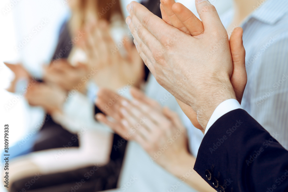 Business people clapping and applause at meeting or conference, close-up of hands. Group of unknown businessmen and women in modern white office. Success teamwork or corporate coaching concept