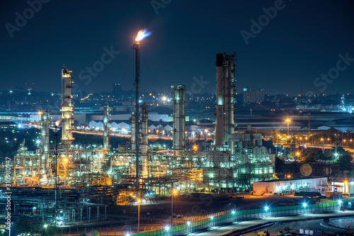 oil refinery and natural gas storage tank at night