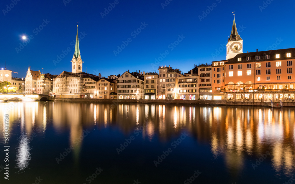 Zurich skyline with St. Peter church along the Limmat river during twilight