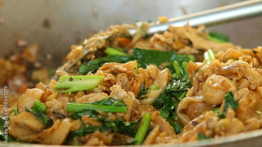 Frying noodle with chopped pork and Chinese kale in pan, Thai street food