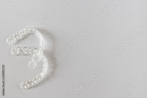 Top view of invisalign braces or invisible retainers on grey background, new orthodontic equipment