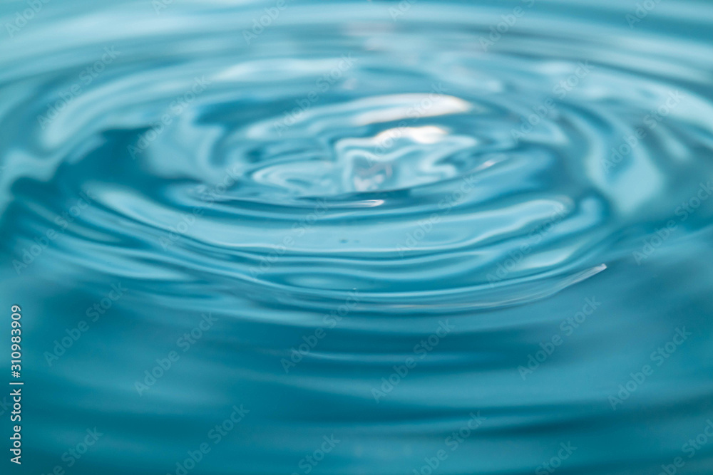 Closeup Water drop falling on the surface of the water and beautiful circular wave ripple, fresh natural mineral water drink water concept