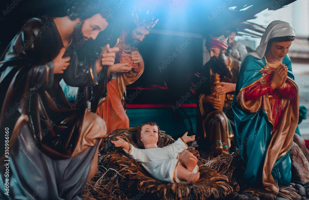 The statue of Mary Joseph and Jesus, Jesus' birthday baby is a statue of Maria and Joseph and Jesus, a newborn baby. There is a beautiful aura light on the hay. Christmas nativity scene