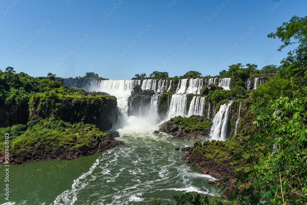 Famous Iguazu waterfalls with beautiful clouds. Declared a World heritage and one of the seven Natural Wonders of the World Brasil Argentina. Iguazu National Park