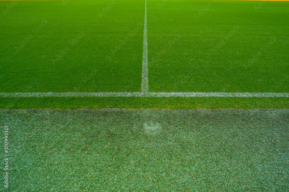 Obraz premium Top view of green football ground or soccer field with white stripes.