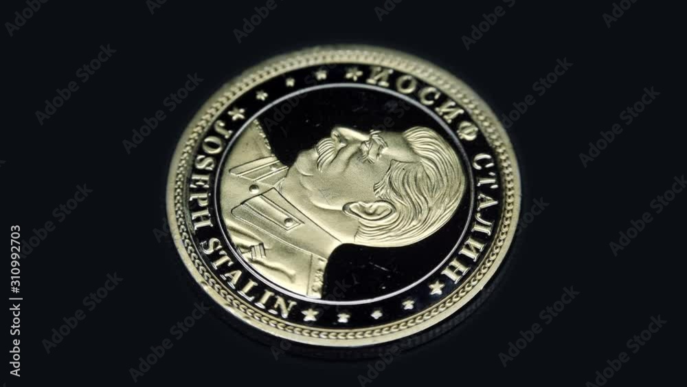 Russian souvenir coin Joseph Stalin rotates on a black background. Macro. Closeup Russian souvenir coin Joseph Stalin rotates on a black background. Macro. Closeup