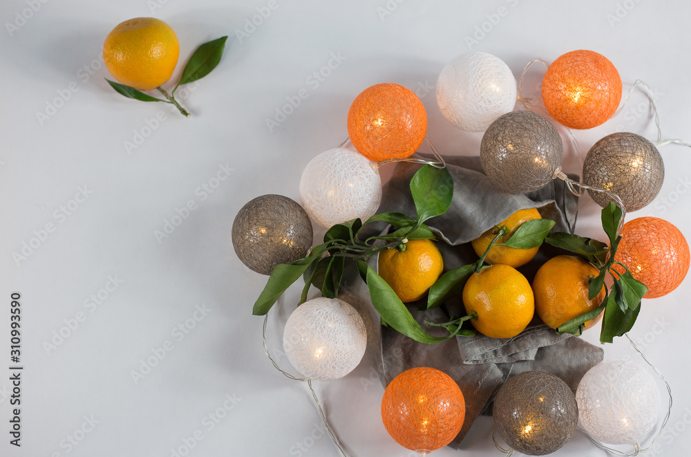 Tangerines with Christmas lanterns on white background with linen napkin. keyboard layout