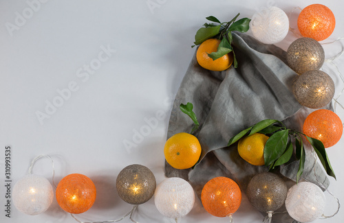 Tangerines with Christmas lanterns on white background with linen napkin. keyboard layout