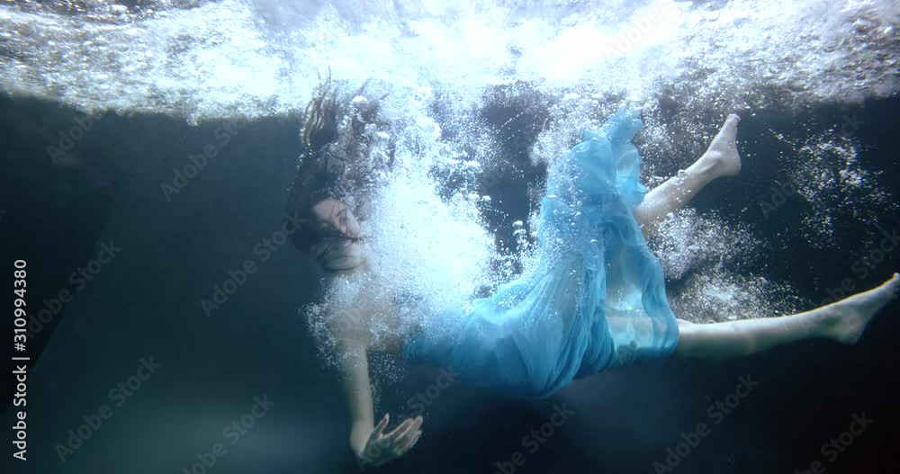 woman in blue dress falls down into water slow motion woman in blue dress falls down into water slow motion