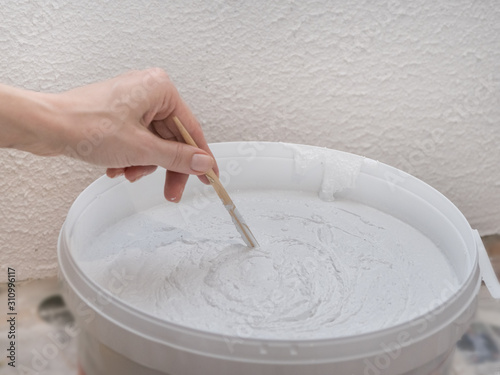 Fotografi Worker mixes construction putty in a bucket.