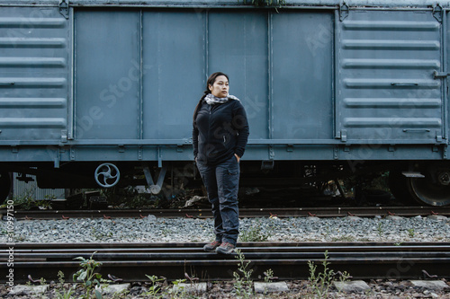 Solo traveller : Asian woman tourist is solo traveling and stand alone at railroad in train station. travel concept