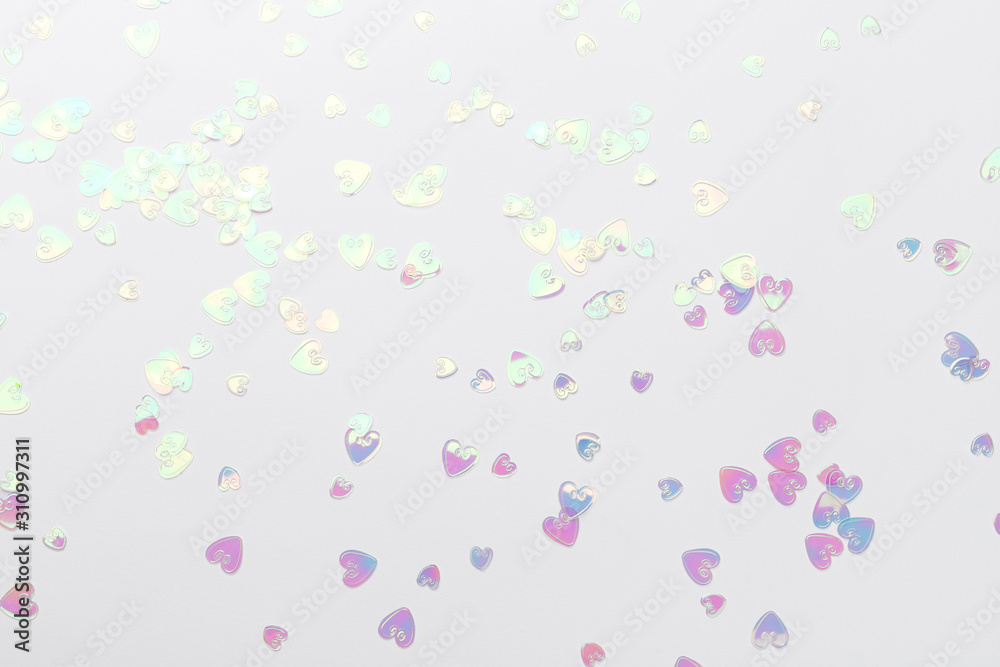 Holographic glitter confetti in heart shape on white background