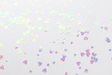 Holographic glitter confetti in heart shape on white background