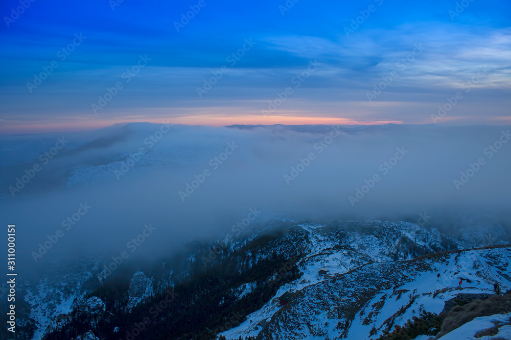 Ceahlau mountain and mystic clouds moving at sunset. Romania