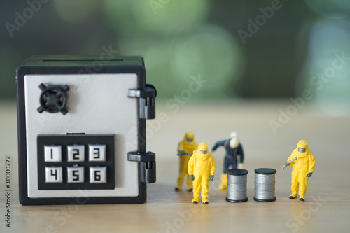 Miniature people chemical team in hazmat suits and miniature safety box