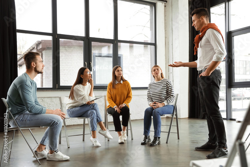 Psychotherapist working with patients in group therapy session indoors