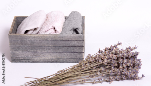 textile things towels, napkins, linen, cotton, dry lavender flowers, wooden box on the concept of order, comfort, close-up, light background, copy space photo