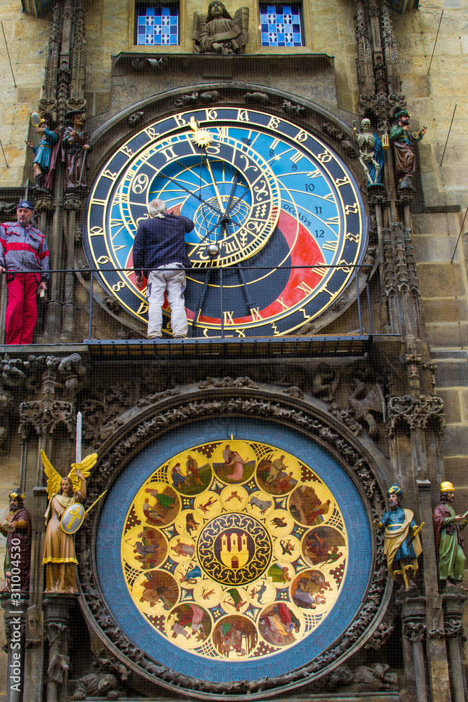 Vertical picture of Prague Astronomical Clock (Prague Orloj, Pražský orloj) in the facade of the Old Town Hall (Staroměstská radnice) of Prague, Czech Republic, with men repairing it