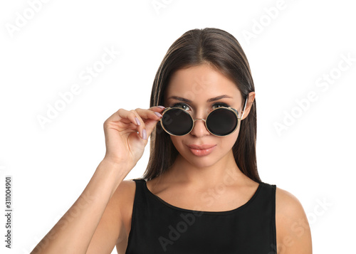 Beautiful young woman wearing sunglasses on white background