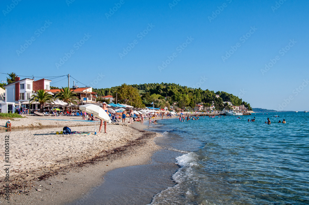 Halkidiki, Greece - August 30,2019: Siviri golden Beach and beach tourists. The place of Siviri in Halkidiki, Greece. Blue sea on Aegean sea.