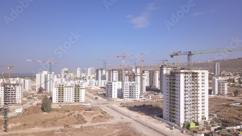 Residential construction site. Tower cranes build large residential buildings. Aerial view of new city construction site.