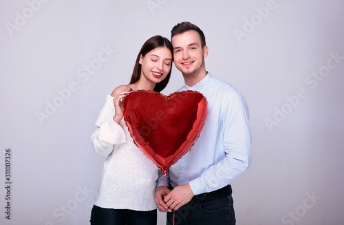 A cute gorgeous couple of lovers posing in the studio on Valentine's Day.