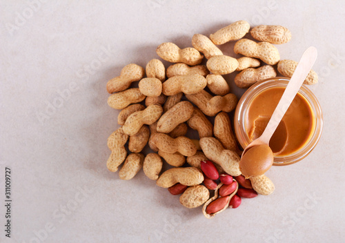 Peanut butter in a jar and peanuts in shells