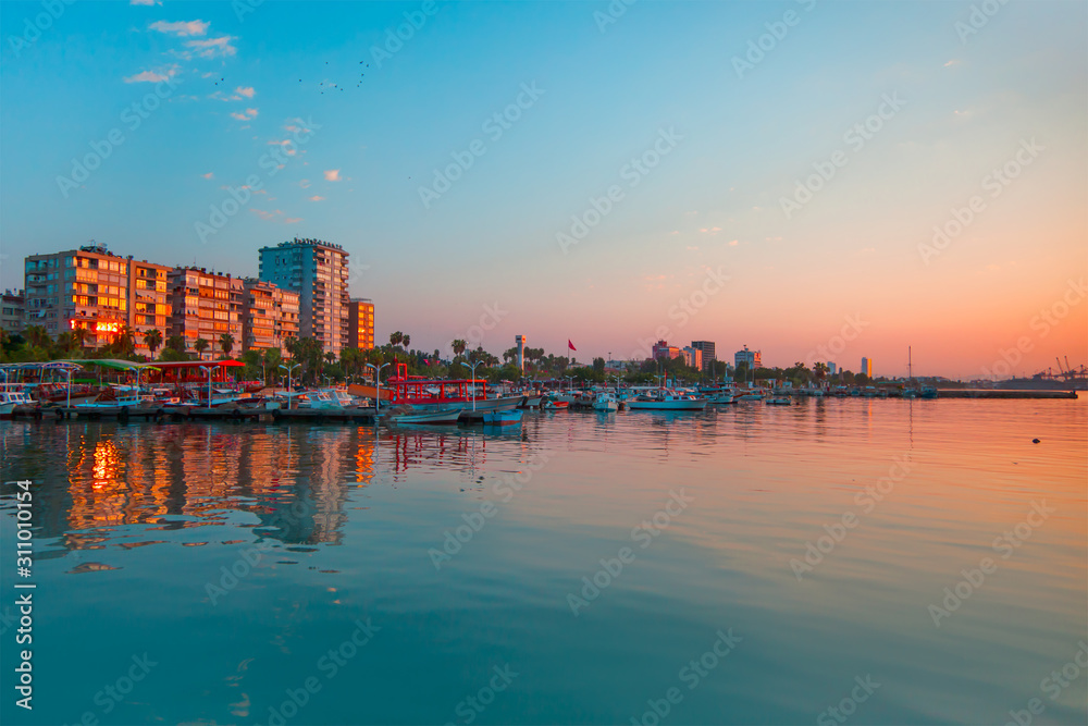 Mersin city coastline with Fishing Boats docked at Mersin Harbor at sunset