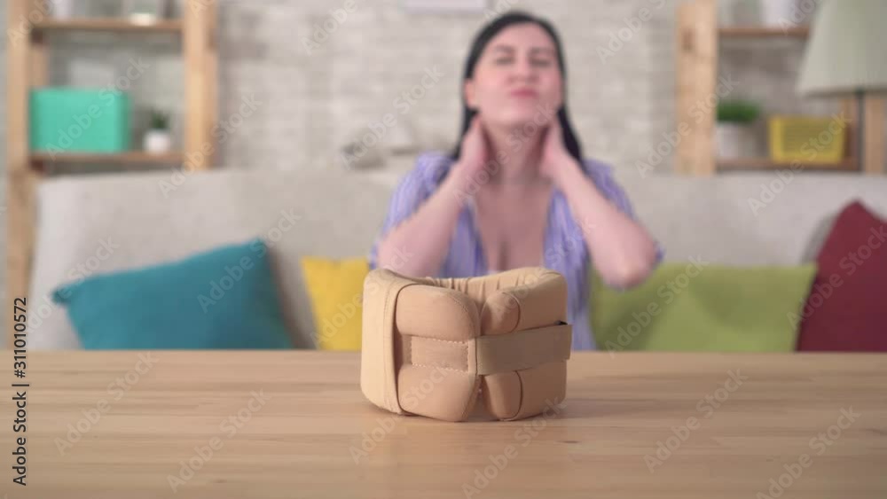 Collar from neck pain and in the background a young woman with neck pain Collar from neck pain and in the background a young woman with neck pain