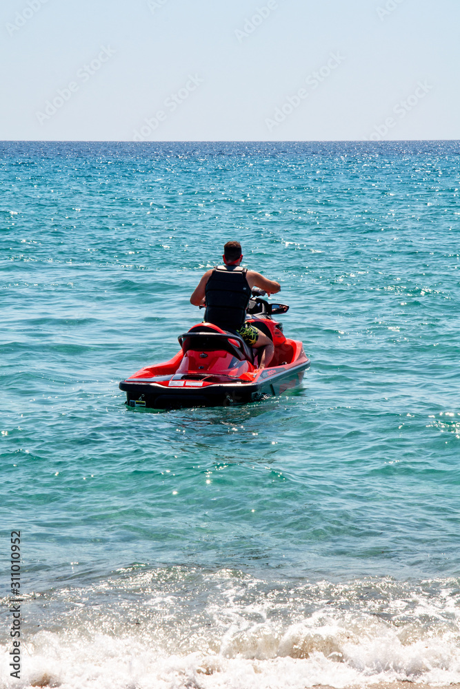 Halkidiki, Greece - September 01,2019: Possidi Beach on Halkidiki, Greece. Personal watercraft or Water motorcycle. Blue sea and a jet ski floating on Aegean sea.