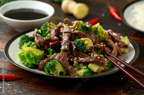 Homemade Beef and Broccoli with Rice and herbs on wooden table photo