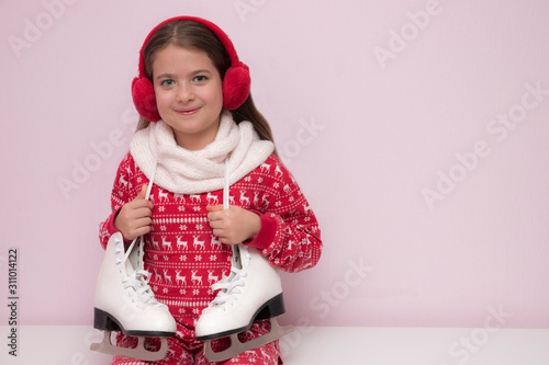 beautiful girl in red pajamas, a scarf and with figure skates for ice