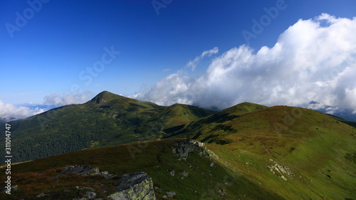 Beautiful green mountain ridge with clouds.