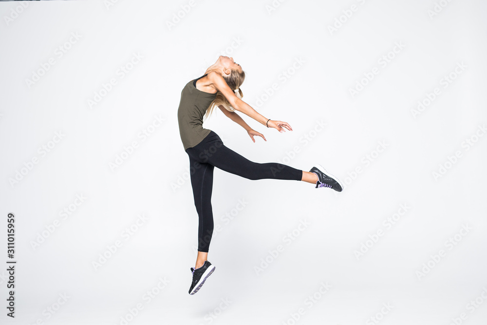 Excited sporty woman jumping isolated on white background