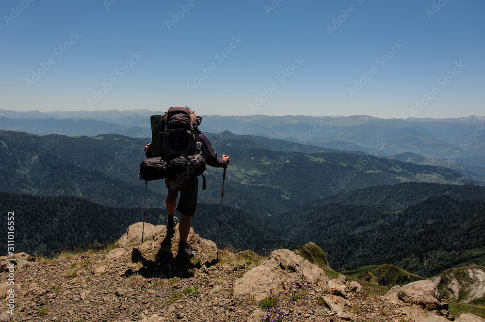 Wanderer on mountain top looks at the scenery