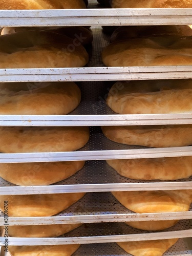 close-up of freshly baked flour pastries on a rack, soft hot tortillas / bread in a bakery