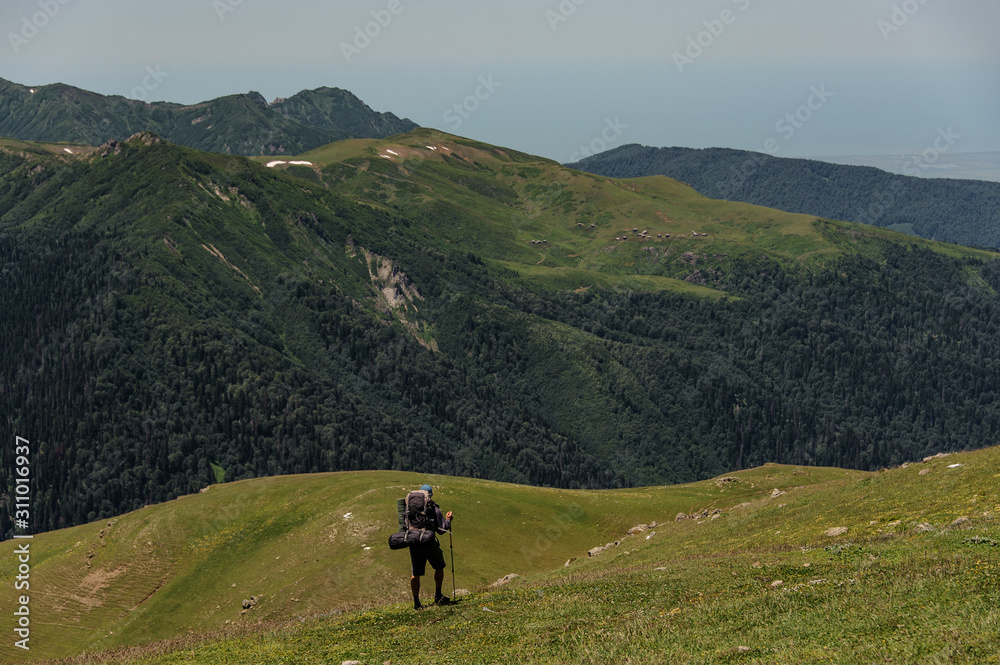 Traveller looks at the scenery with hills and forest