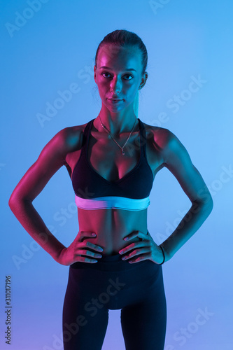 Young fitness woman isolated on purple background