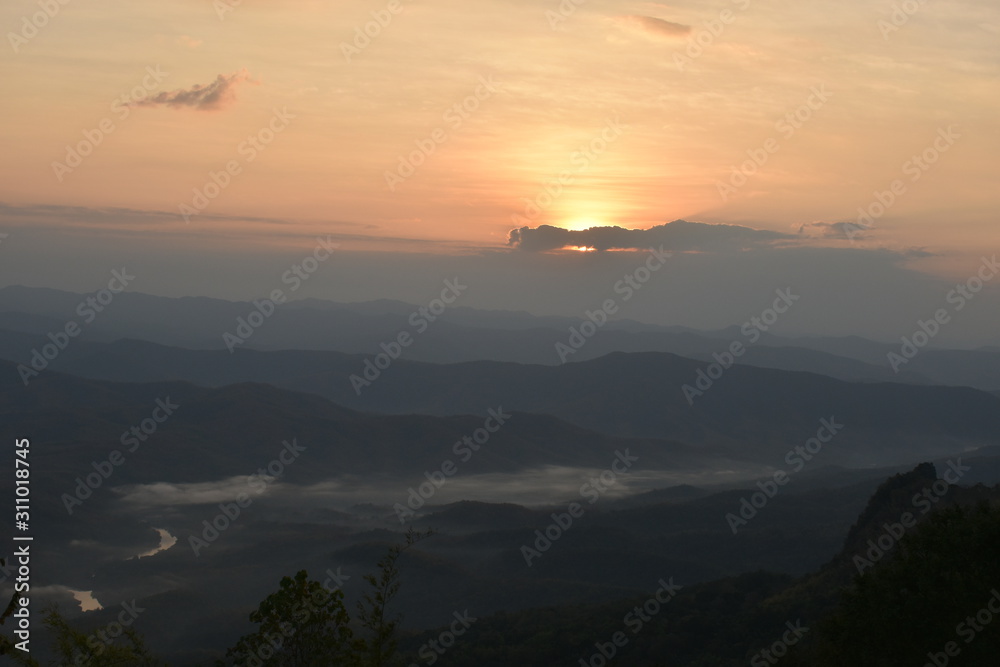 Obraz premium Morning clouds with the sunrise on foggy landscape