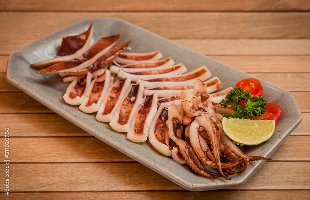 Grilled squid japanese seafood on brown wooden plate stock photo