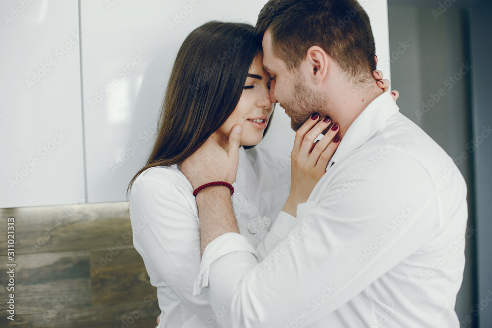 Cute couple on a kitchen. Pretty brunette in a white shirt. Cute couple on a kitchen. Pretty brunette in a white shirt.