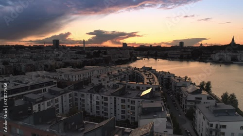Aerial view of apartment buildings in Hammarby sjöstad district in Stockholm, Sweden. Drone shot flying over buildings in Sickla. Water canal and skyline at sunset
