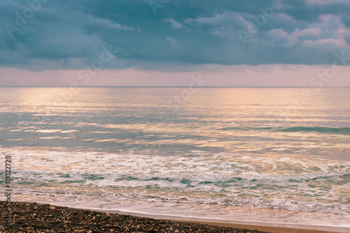 Calm sea waves against a dark and stormy sky photo