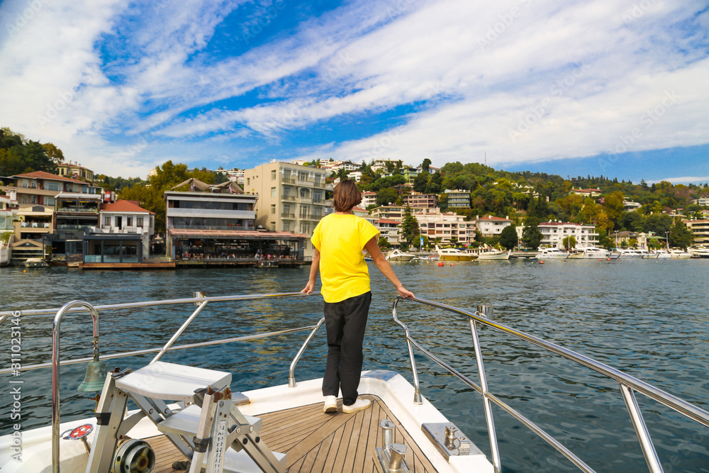 Woman traveller in a yellow t-shirt on a private yacht during Bosphorus cruise in Istanbul Turkey. Woman traveller in a yellow t-shirt on a private yacht during Bosphorus cruise in Istanbul Turkey.