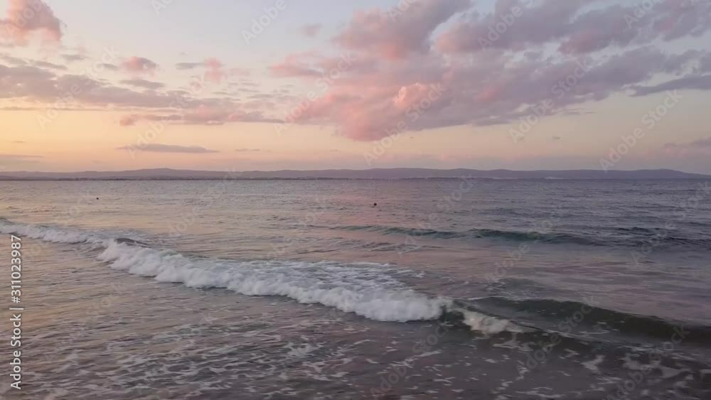 Aerial view of a sea surface with blue water waves under sunset sky. Aerial view of a sea surface with blue water waves under sunset sky.