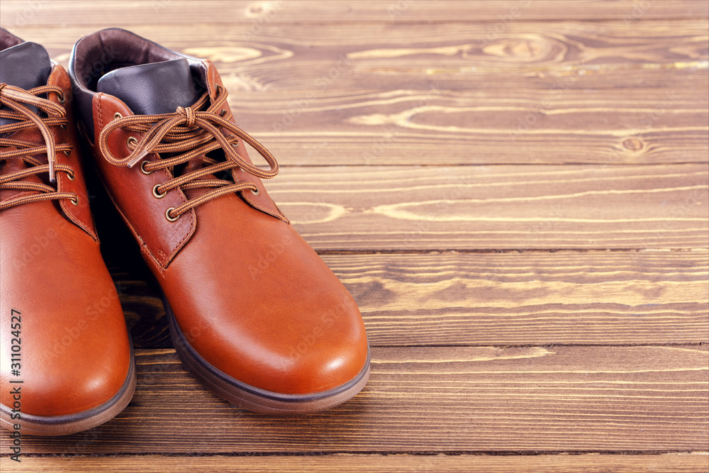 Stylish men's shoes on a wooden background with place for text.