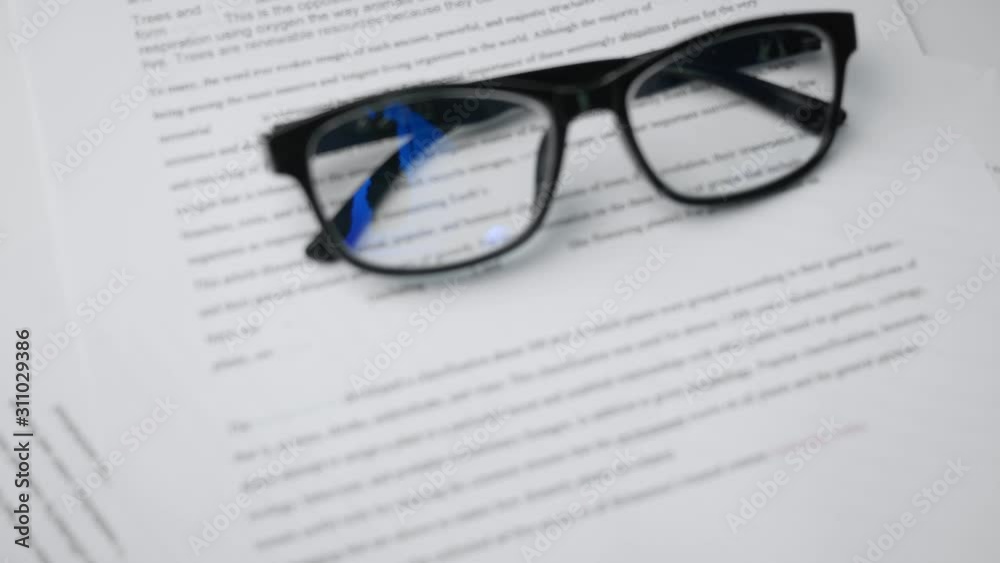 The glasses placed on paper document research of student on table. The glasses placed on paper document research of student on table.