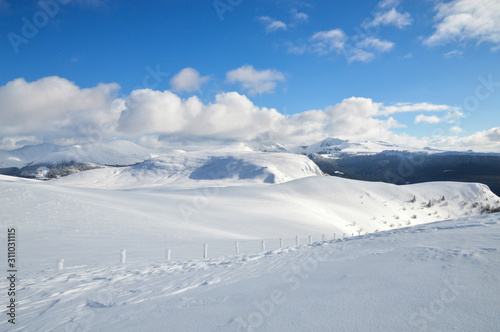 A beautiful viewpoint of the snowy volcanic mountain range during the winter, in Auvergne. © jpr03