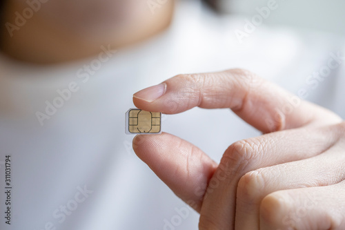 マイクロsimカードを持つ若い女性の指先