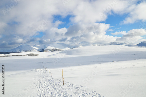 A beautiful viewpoint of the snowy volcanic mountain range during the winter, in Auvergne. photo